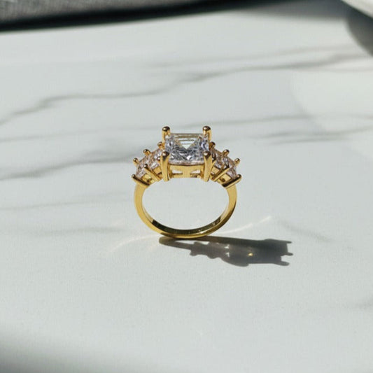 Artificial ring with a large central diamond and smaller diamonds 